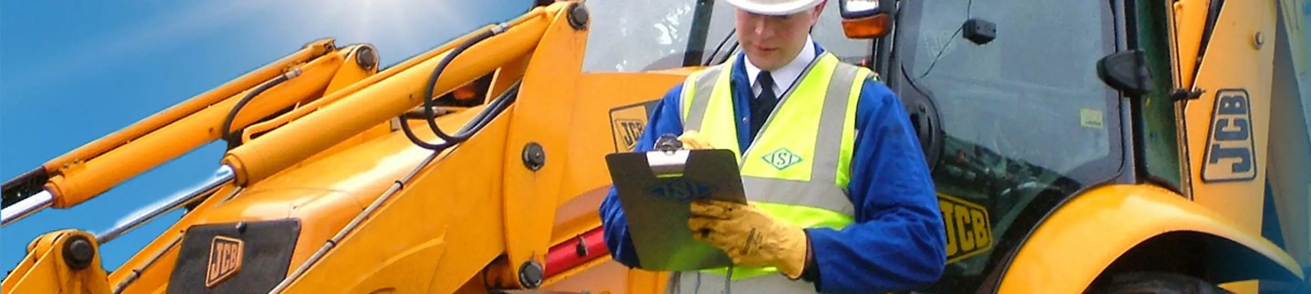 Construction worker standing next to a machine Construction worker standing next to a machine