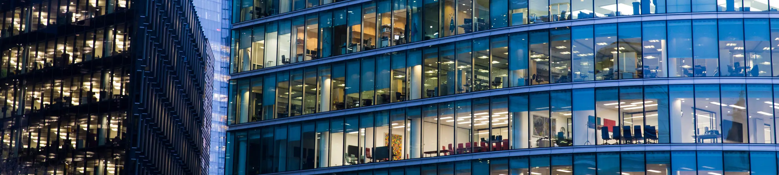 A view of office workers from the outside of a building A view of office workers from the outside of a building
