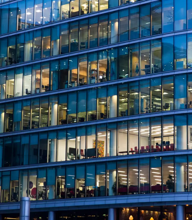A view of office workers from the outside of a building A view of office workers from the outside of a building